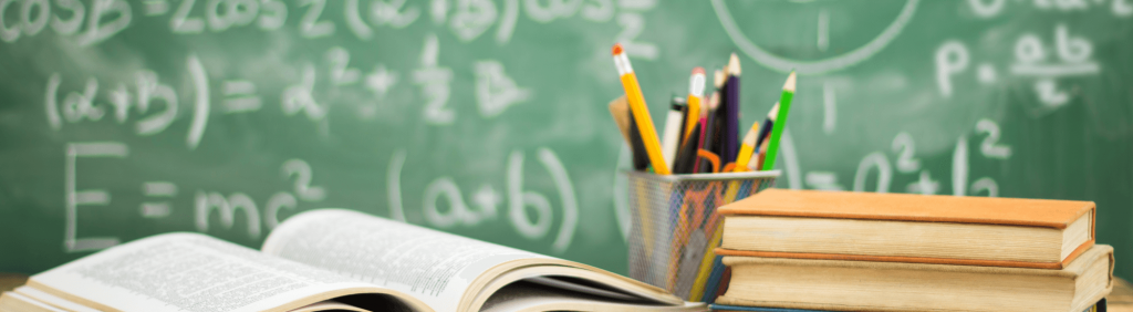 chalkboard with pencils and book in front
